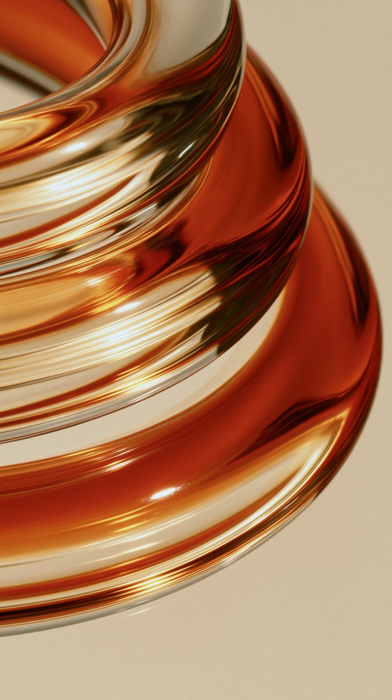 Glossy amber and gold metallic spiral sculpture reflecting light against a minimalist beige background.