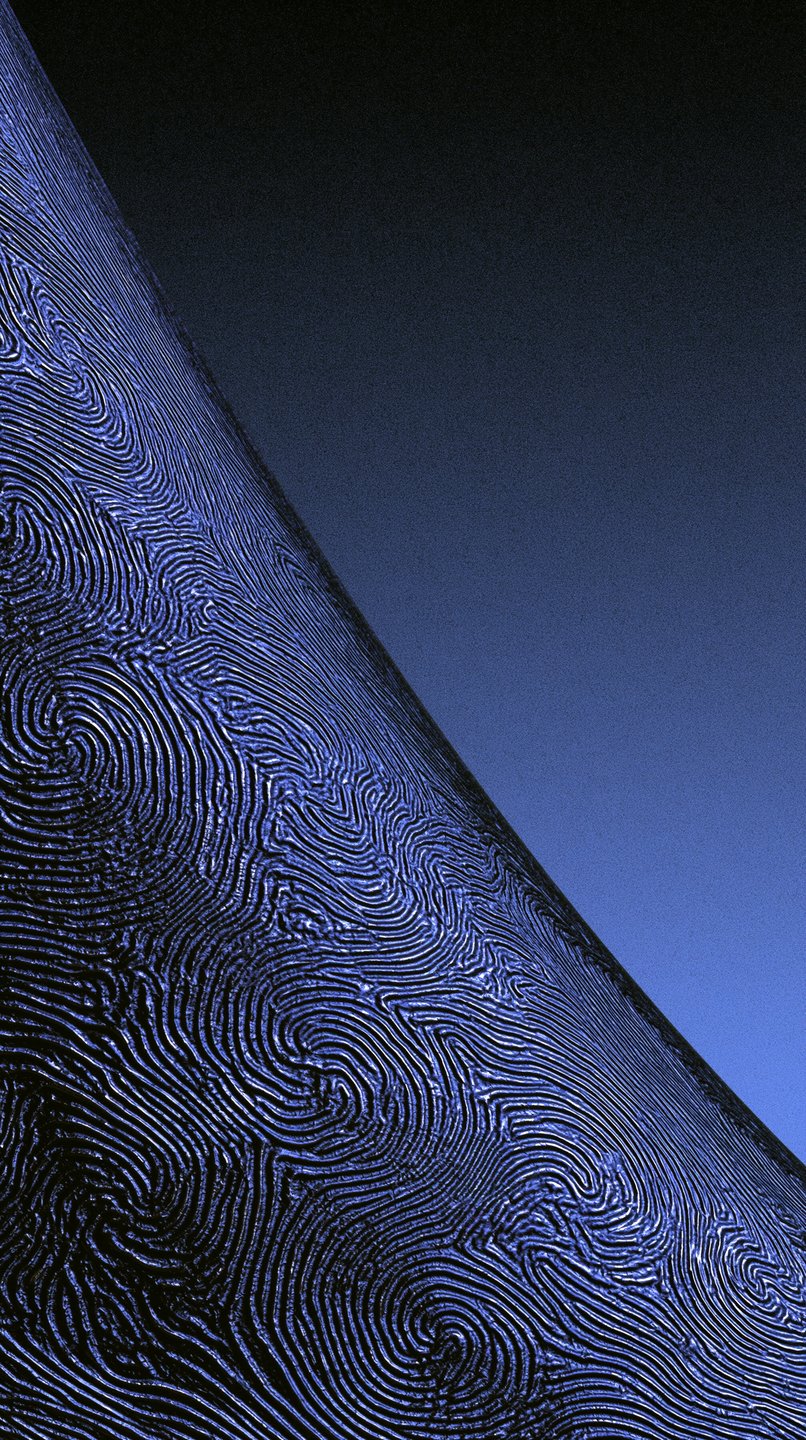 A textured blue metallic surface with swirling ridges diagonally bisecting a smooth dark blue gradient background.