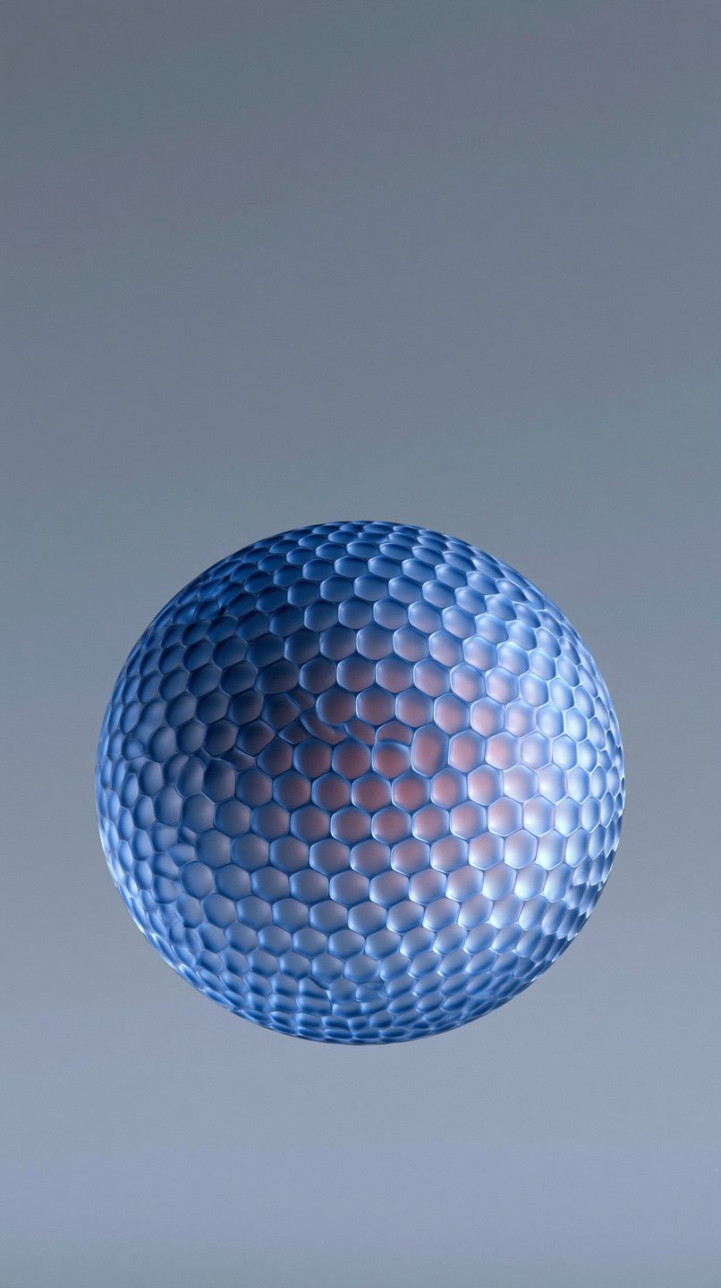 Blue translucent sphere with a hexagonal dimpled texture and a glowing pink center on a grey background.