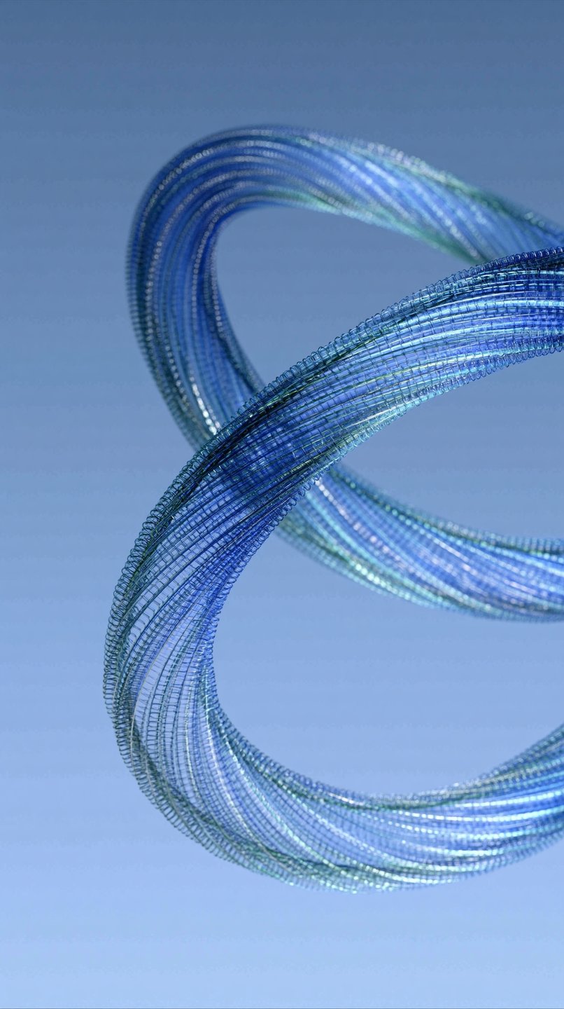 Coiled blue glass helix sculpture floating gracefully against a soft gradient blue background with shallow focus.