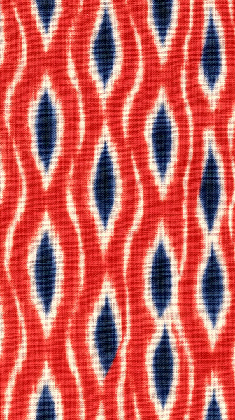 Red and cream ikat fabric with a repeating vertical diamond pattern featuring deep indigo blue centers.