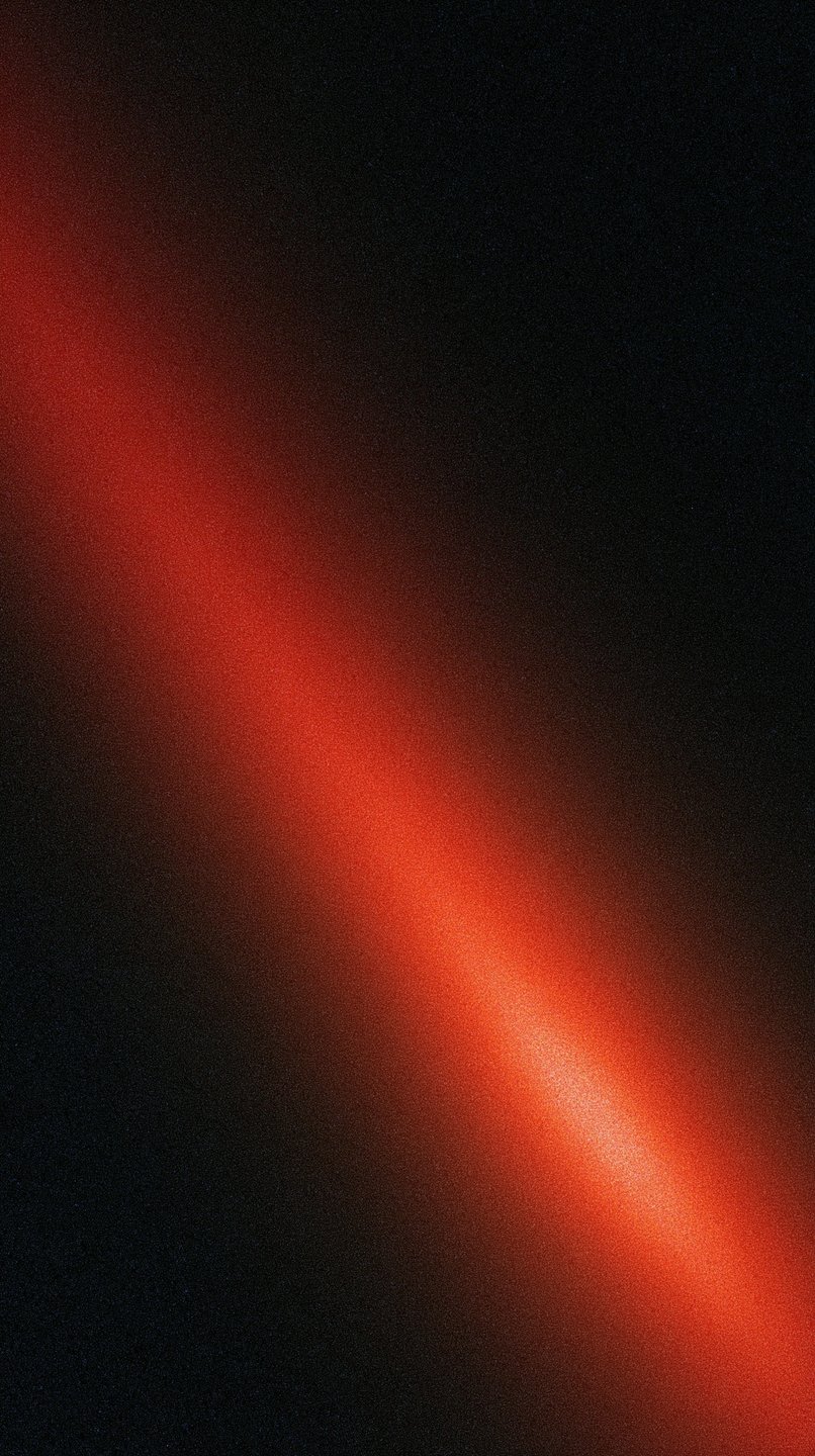 A diagonal red light leak with heavy analog film grain cuts across a dark black background.