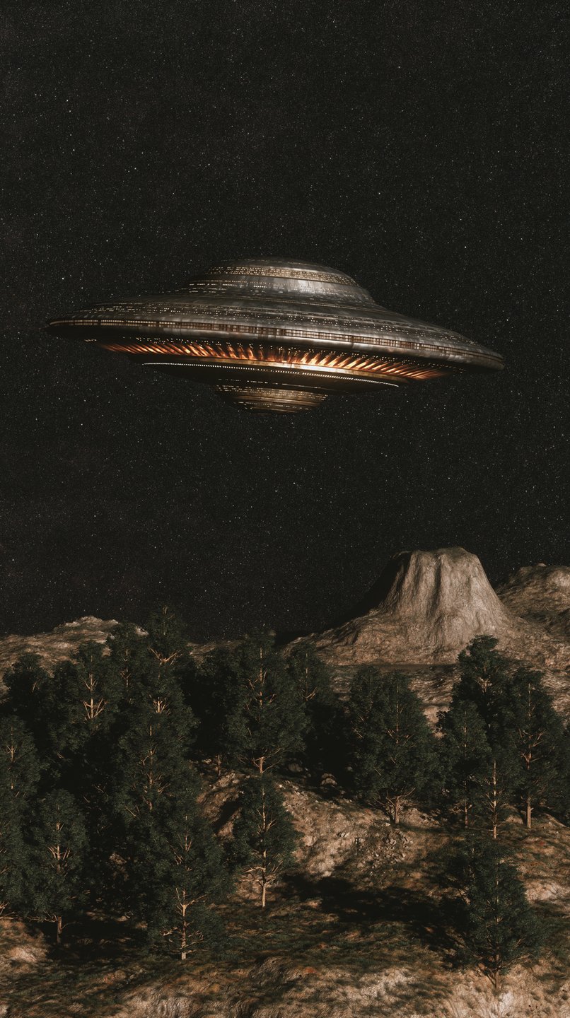 Metallic flying saucer with glowing orange lights hovers over a pine forest under a starry night sky.