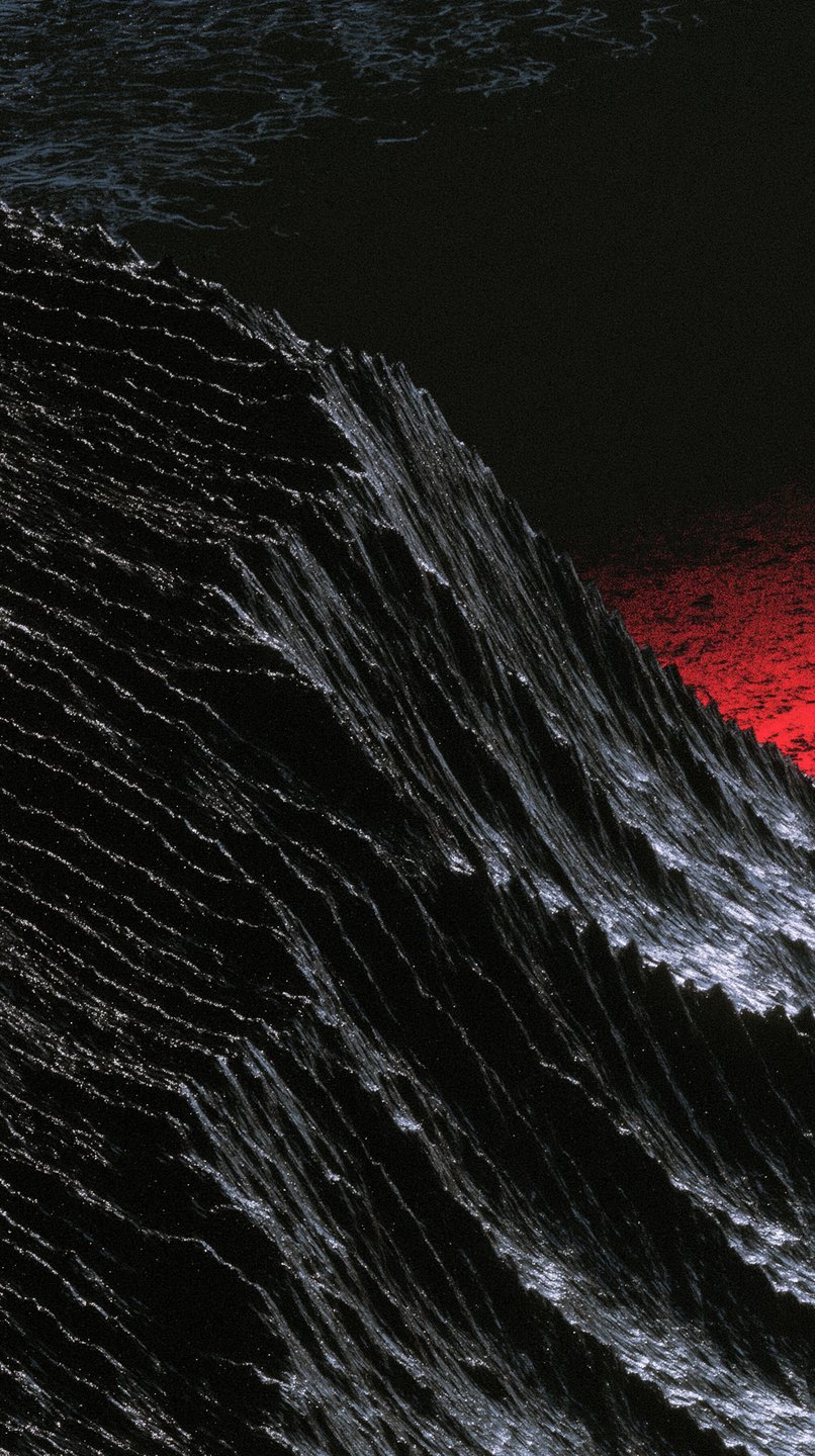 A dark, textured obsidian ridge cuts diagonally across the frame against a stark crimson background.