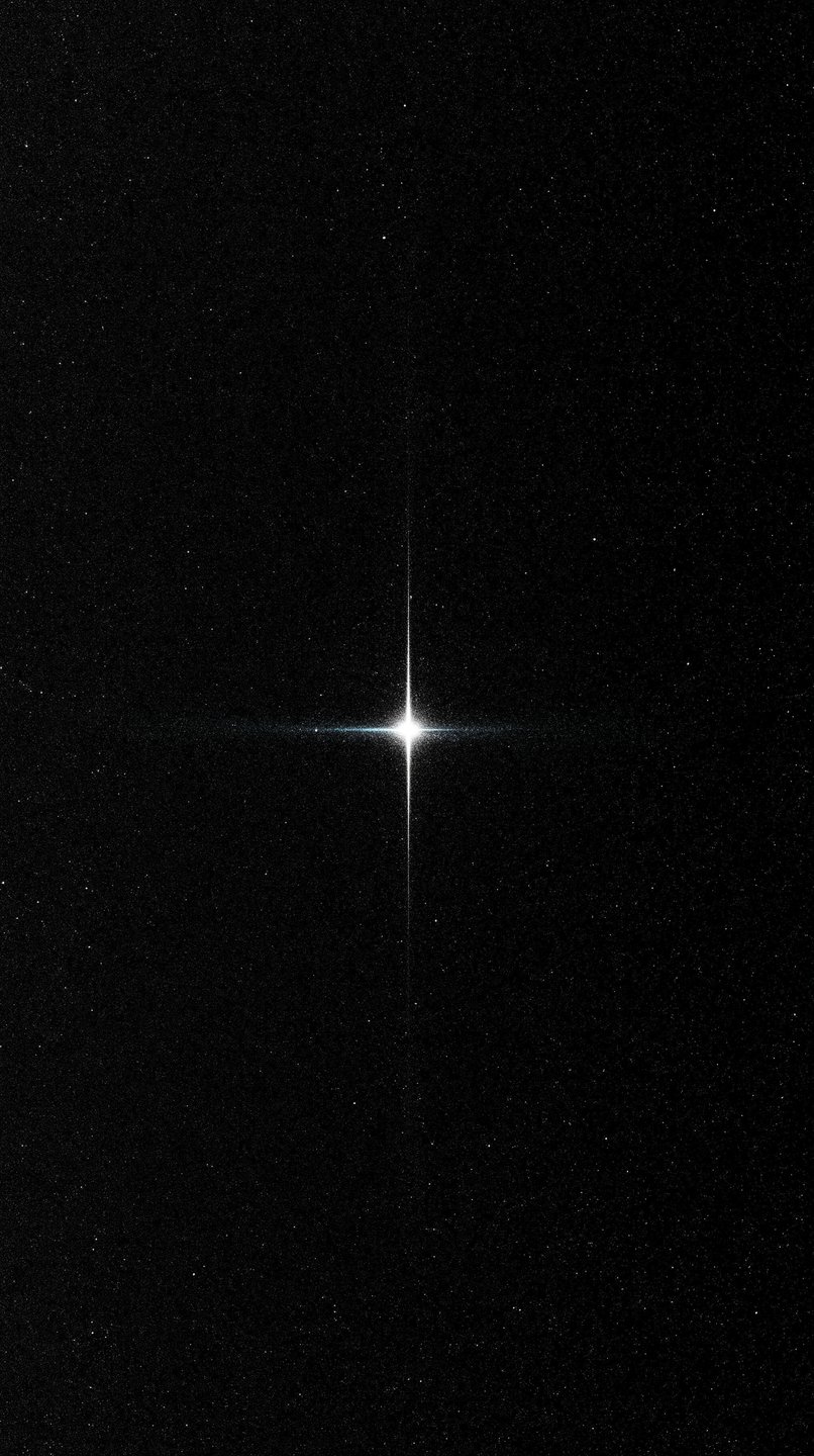 Brilliant four-pointed star shines at the center of a dense, dark field of distant cosmic stars.