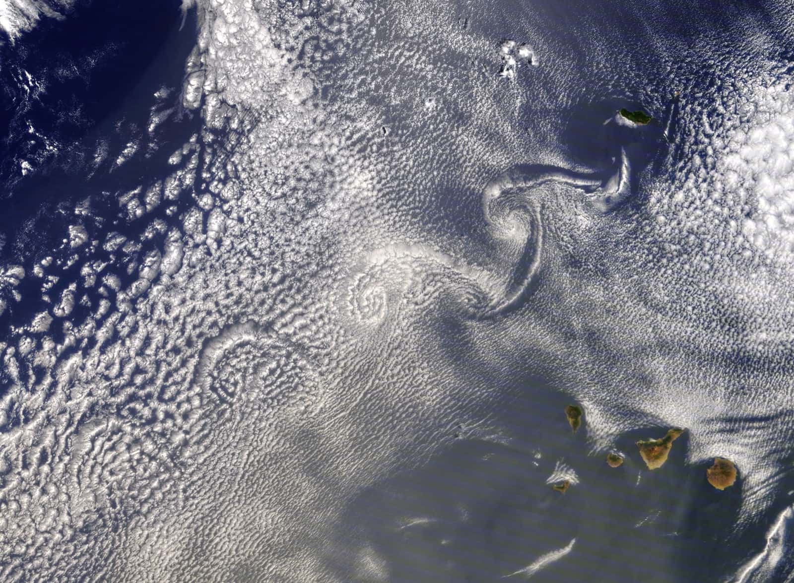 Large cloud swirls trailing south-west from Madeira, the Canary Islands lower right