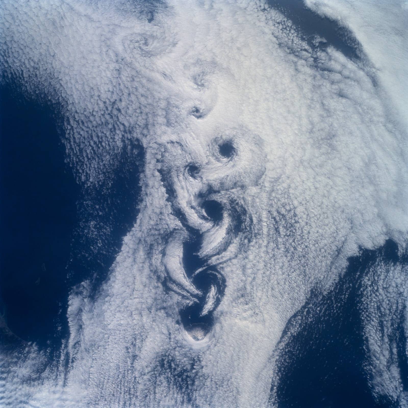 A chain of cloud eddies trailing from the small volcanic island of Rishiri, photographed from the Space Shuttle