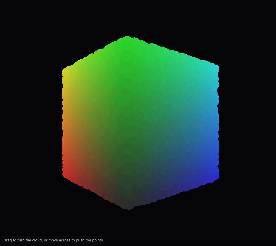A cube turned at an angle, its faces blending through red, yellow, green, cyan and blue, on a dark ground